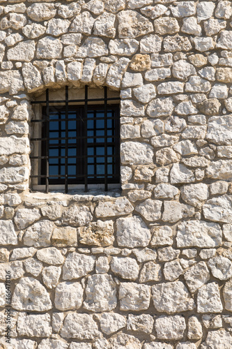 Window with wrought iron bars in the stone wall.