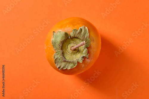 Fotografia Sweet ripe persimmon on orange background, top view