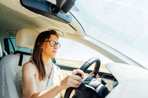 Fotografie beautiful young middle age woman doing driving concentrated with glasses