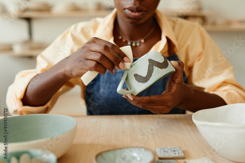 Photo Close up of unrecognizable African-American woman decorating ceramics in pottery