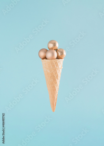 Creative arrangement made of an ice cream cone and Christmas baubles on a blue background. Minimal New Year concept. Summer Christmas inspiration. photo