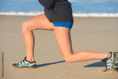 pretty young woman doing stretching on the beach 