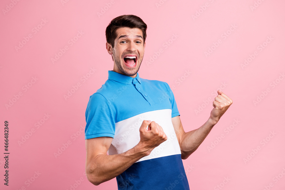 Photo of young excited good mood male raise fists in victory screaming in success isolated on pink color background Photo of young excited good mood male raise fists in victory screaming in success isolated on pink color background