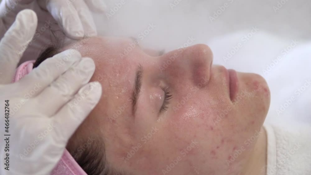 Young woman having a beauty treatment of face with ozone facial steamer in beauty center and a massage with special acids for smooth skin, Closeup Young woman having a beauty treatment of face with ozone facial steamer in beauty center and a massage with special acids for smooth skin, Closeup