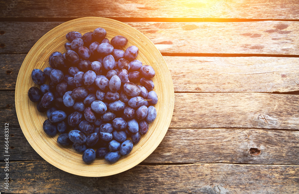 Plate with plums on a rustic wooden background, top view. Plate with plums on a rustic wooden background, top view.