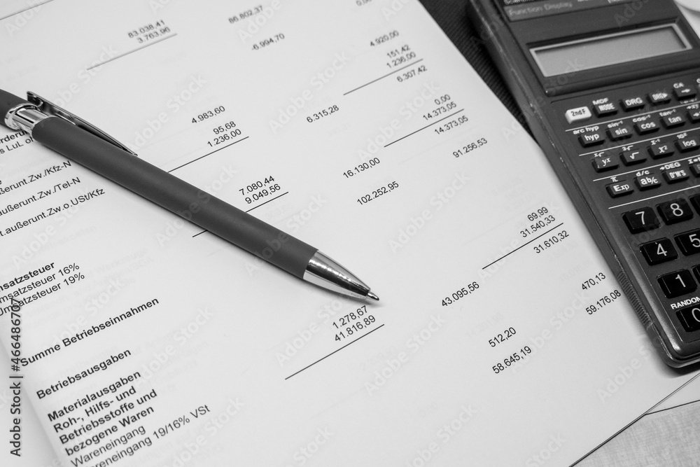 ballpoint pen and a calculator lie on a financial evaluation ballpoint pen and a calculator lie on a financial evaluation