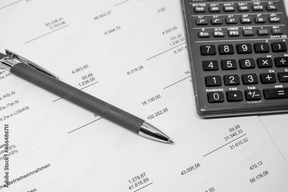 ballpoint pen and a calculator lie on a financial evaluation ballpoint pen and a calculator lie on a financial evaluation