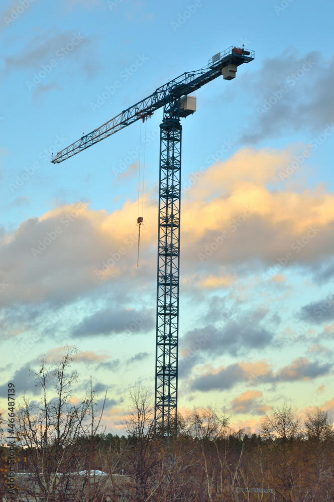 tower crane on a rack against a background of beautiful clouds. tower crane on a rack against a background of beautiful clouds.