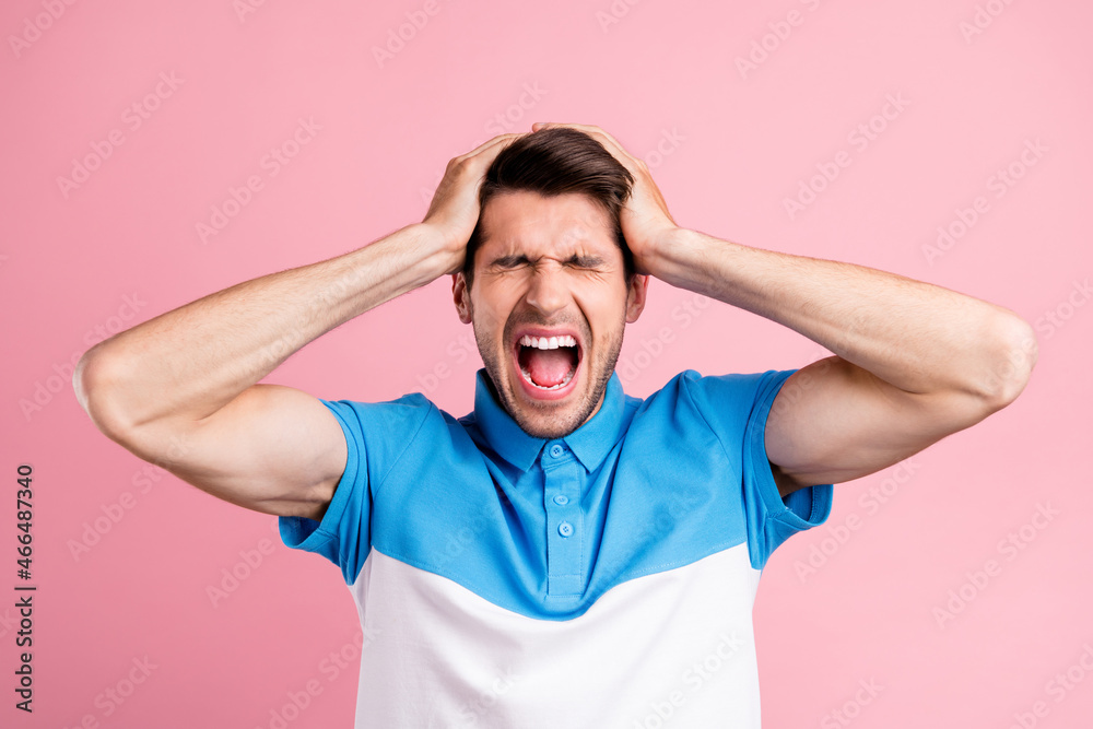 Portrait of young stressed annoyed man screaming have headache suffering isolated on pink color background Portrait of young stressed annoyed man screaming have headache suffering isolated on pink color background