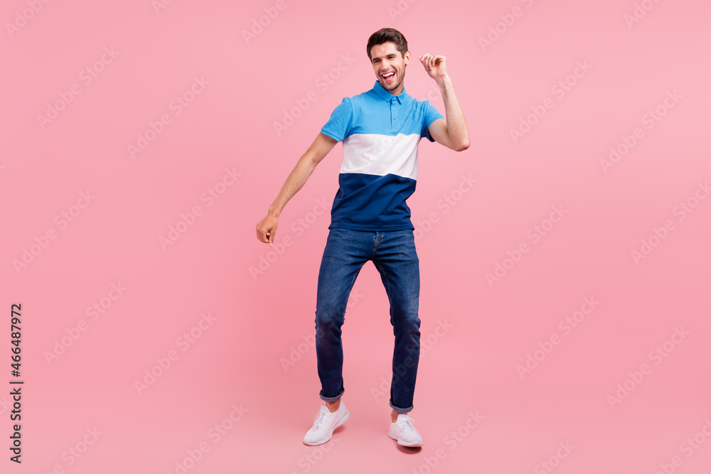 Full size photo of cool brunet millennial guy dance wear polo jeans sneakers isolated on pink background