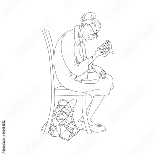 An old retired woman examines a check, an invoice for the purchase of groceries. Poverty old age concept.