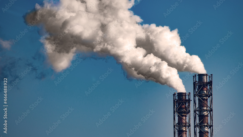 Smoke stack of coal power plant on blue sky background. Place for text
