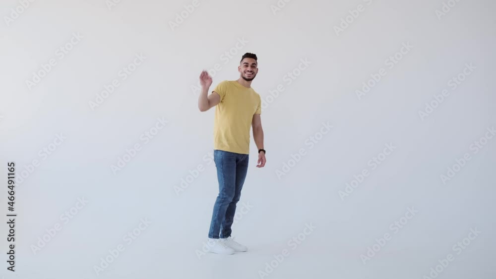 Happy young man dancing while walking over white background Happy young man dancing while walking over white background