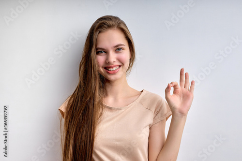 Everything will be OK. positive teenage girl with long hair showing ok gesture and smiling, life is good. attractive lady in casual wear look at camera, having nice smile. caucasian girl portrait