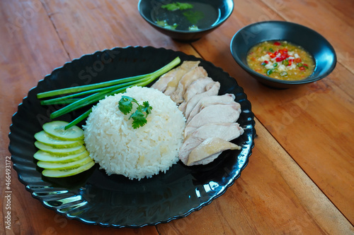Steamed rice topped with chicken on the table.