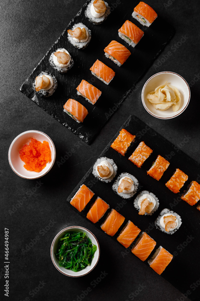 set of rolls with salmon, sauce, wasabi, hiashi wakame on a dark background set of rolls with salmon, sauce, wasabi, hiashi wakame on a dark background