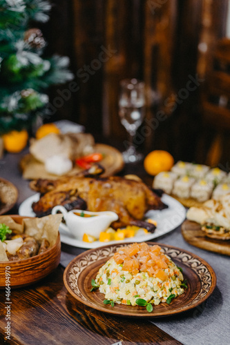 festive New Year's table with delicious dishes in the Soviet style, olives, baked meat, lard, champagne