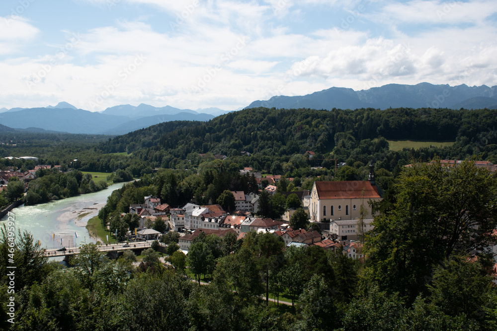 View of the western part of the town of Bad Tölz and the Isar river in Upper Bavaria in Germany on a summer day, with the Alps in the distance