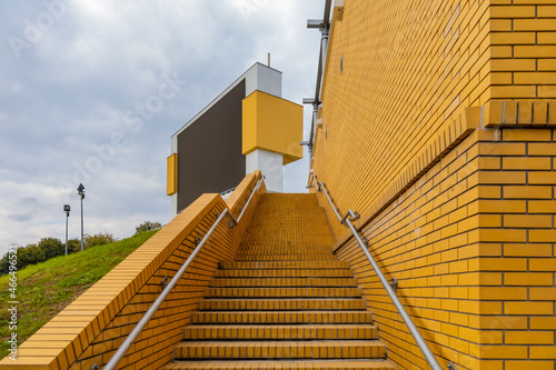 Long yellow brick stairs to place with big totem with big black screen photo