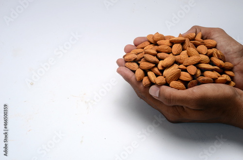 Fresh almonds in the wooden bowl, Organic almonds, almonds border white background, Almond nuts on a dark wooden background. Healthy snacks. Top view. Free space for text.
 photo