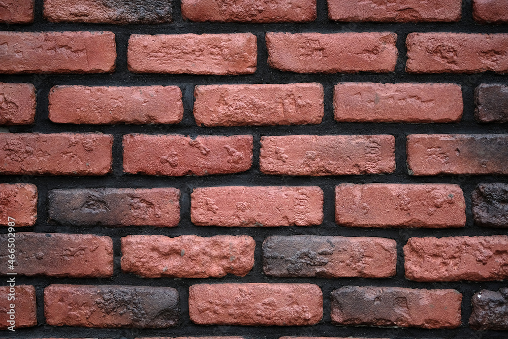 Red brick wall with black seams background. Decorative wall with brown tiles and black cement. Brick wall texture close-up. Red brick wall with black seams background. Decorative wall with brown tiles and black cement. Brick wall texture close-up.