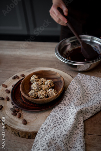 Chocolate truffles in wooden plate on the table on the kitchen. Close-up. Copy space. 