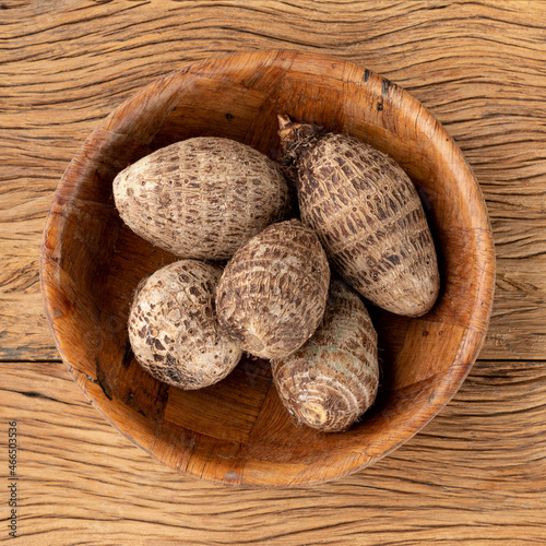 Raw yams or inhames on a bowl over wooden table photo