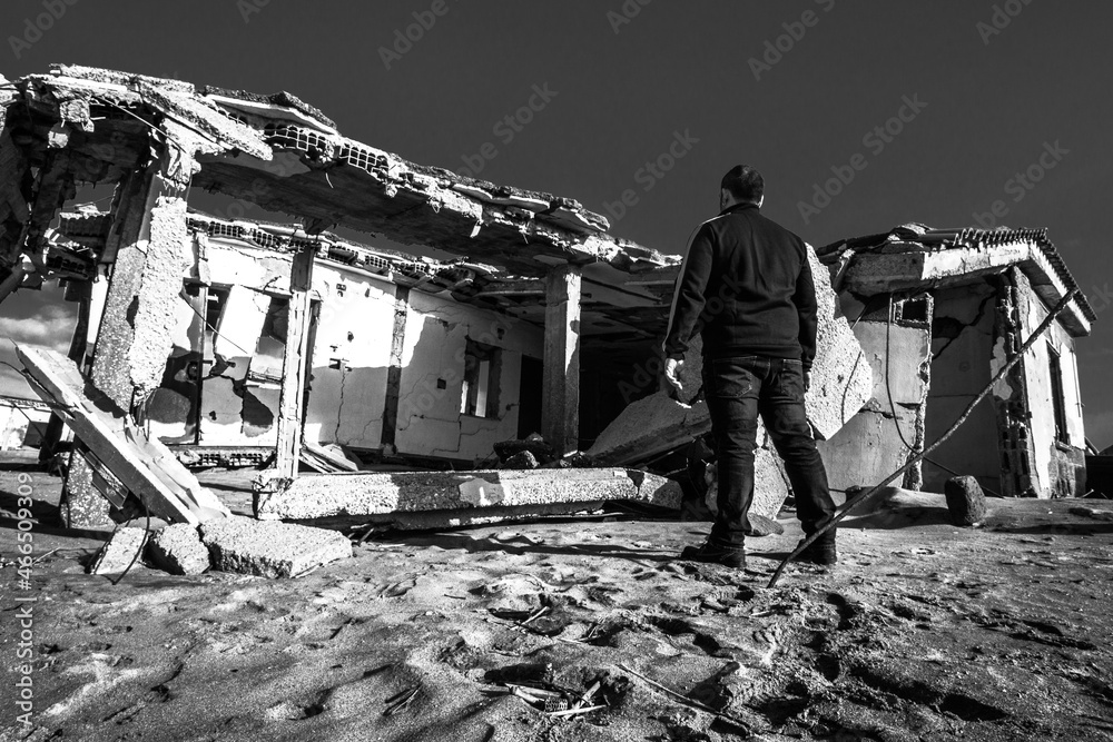 Man standing in front of damaged property in Castel Volturno near Naples Italy.