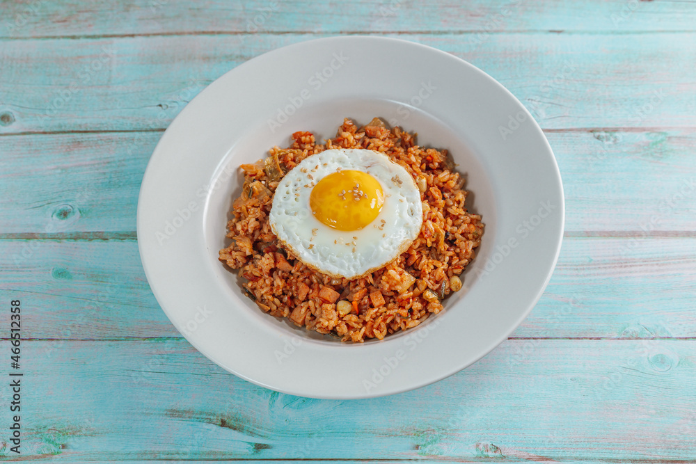 Korean food kimchi fried rice dish with fried egg on white plate Korean food kimchi fried rice dish with fried egg on white plate