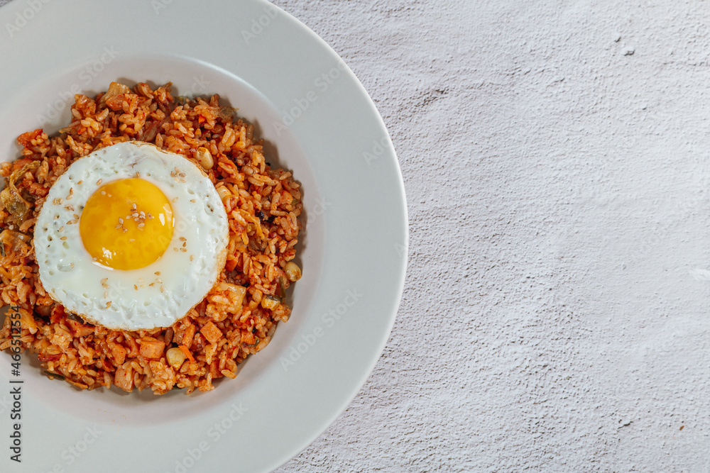 Korean food kimchi fried rice dish with fried egg on white plate Korean food kimchi fried rice dish with fried egg on white plate
