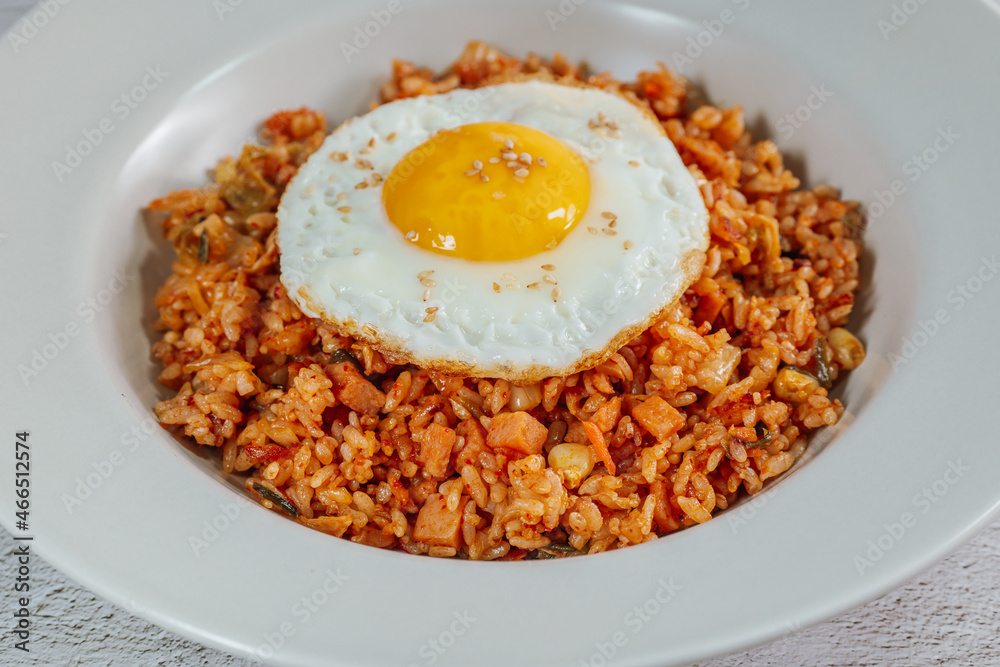 Korean food kimchi fried rice dish with fried egg on white plate Korean food kimchi fried rice dish with fried egg on white plate
