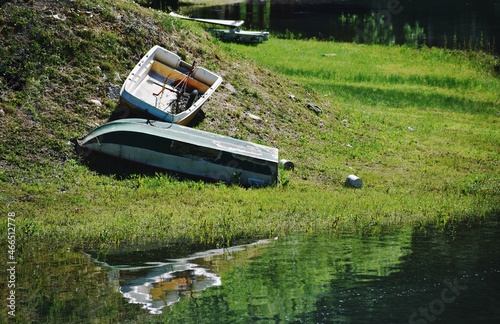 barche a remi rovesciate sulla riva del lago di Gramolazzo in Garfagnana, riflese nelle acque photo