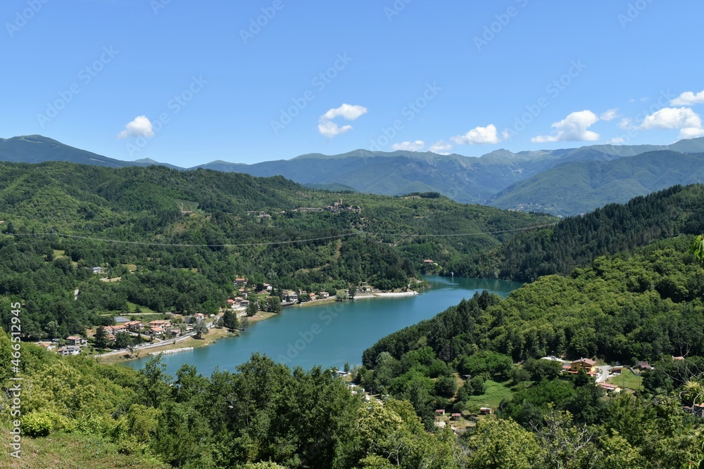 Gramolazzo lake in Lunigiana, with boats and reflections, blue sky and no clouds, Apuan Alps in the background