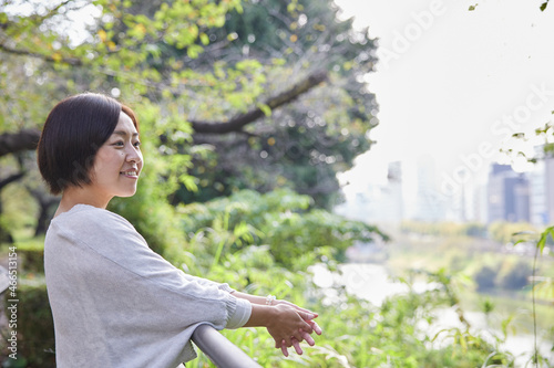 手すりに肘をかけ景色を楽しむ日本人女性