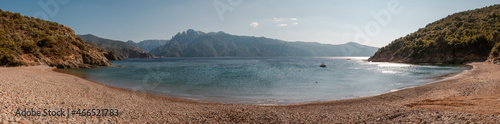 Panoramic view of Plage de Gradelle beach in Corsica with the tower of Porto and mountains in the distance