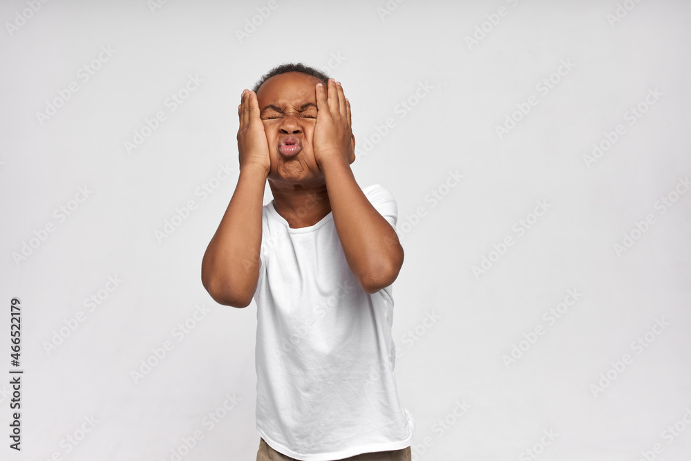 Funny African American boy fooling around making grimaces, patting
