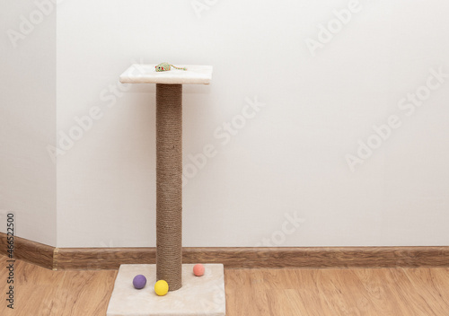 scratching post with plush resting platform at top on brown floor. Pet Equipment. copy space photo