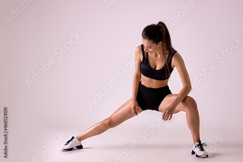 Concentrated Caucasian Fit Female In Sportswear Doing Lunges In Studio On Pink Background, Portrait Of Fit Lady Engaged In Sport, Weight Loss, Workout. Attractive Brunette Is Exercising © alfa27