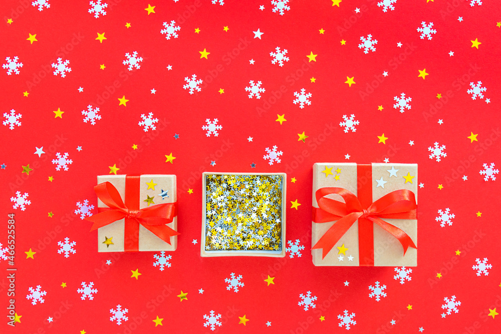 Three Christmas gifts with snowflakes, gold and silver stars in a box, on a red background. New Year 2022. Three Christmas gifts with snowflakes, gold and silver stars in a box, on a red background. New Year 2022.