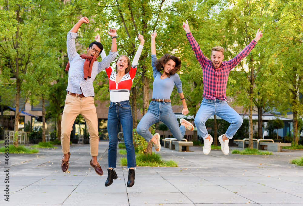 Group of exuberant young friends cheering and leaping in air - obrazy, fototapety, plakaty 