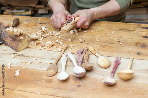 Spoon master in his workshop with wooden products and tools