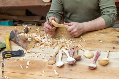Spoon master in his workshop with wooden products and tools