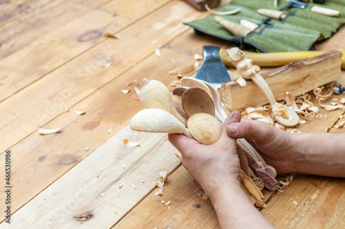 Spoon master in his workshop with wooden products and tools