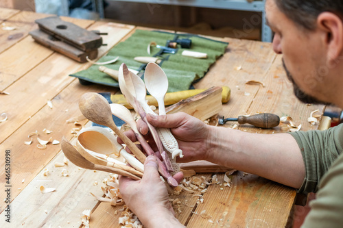 Spoon master in his workshop with wooden products and tools