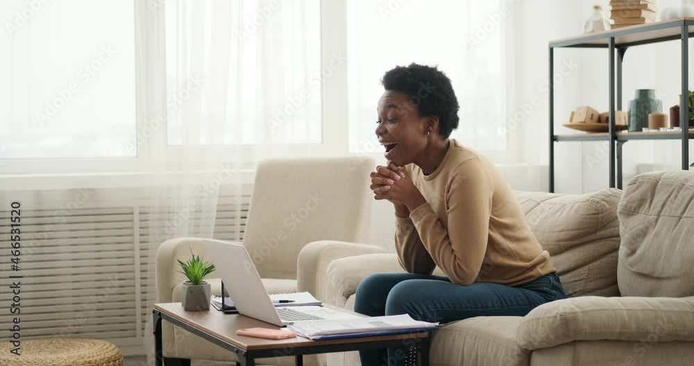 Woman celebrating online success using laptop at home Woman celebrating online success using laptop at home