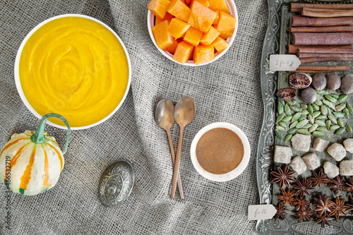 Pumpkin spice ingrediens for fall dessert. Autumn baking background with pumpkin and cinnamon sticks, sugar and anise stars.  photo