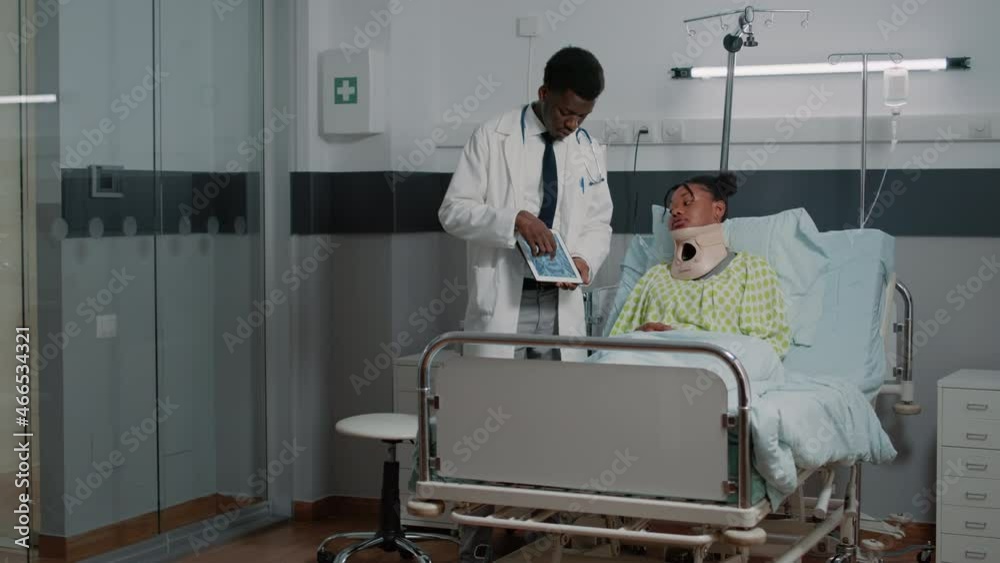 Specialist explaining radiography to woman with neck collar in hospital ...