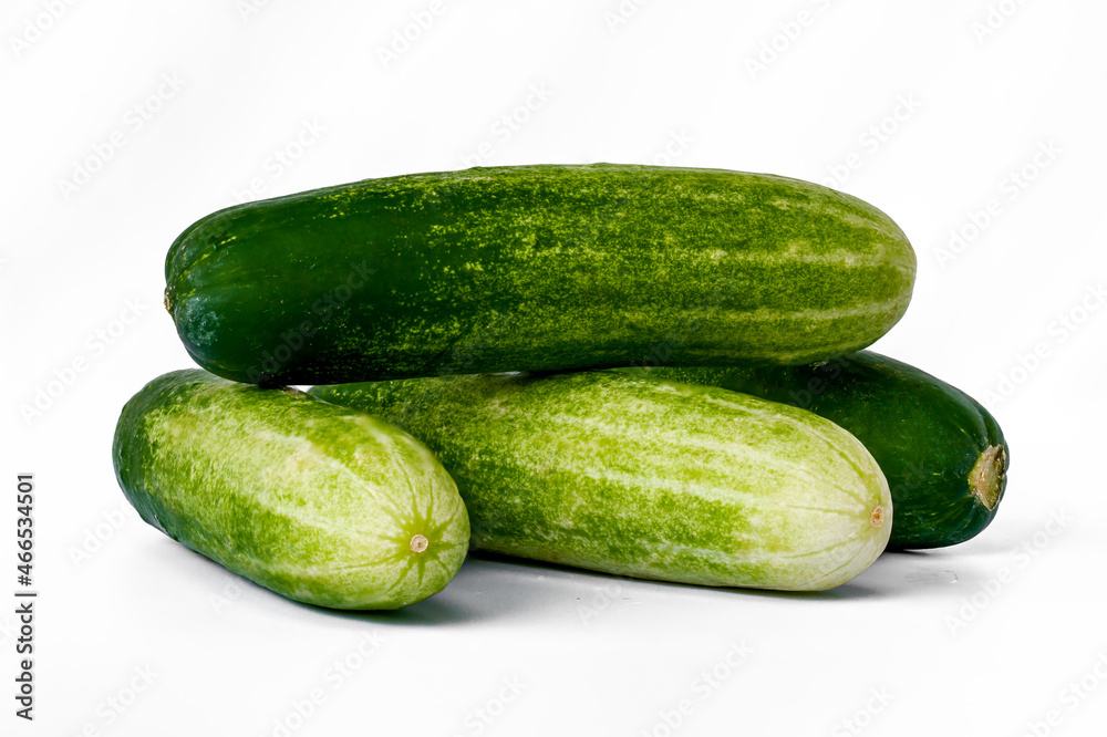 Four cucumbers for greens, in a stack composition, isolated on a white background, copy space Four cucumbers for greens, in a stack composition, isolated on a white background, copy space