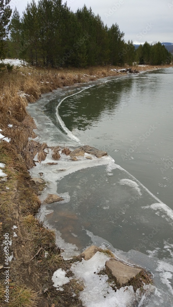 Late autumn. It's already cold and snowing. The mountain river begins to freeze and is covered with ice. Late autumn. It's already cold and snowing. The mountain river begins to freeze and is covered with ice.