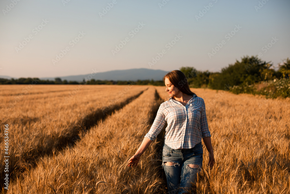 Charming woman enjoying moment, walking in grain field Charming woman enjoying moment, walking in grain field
